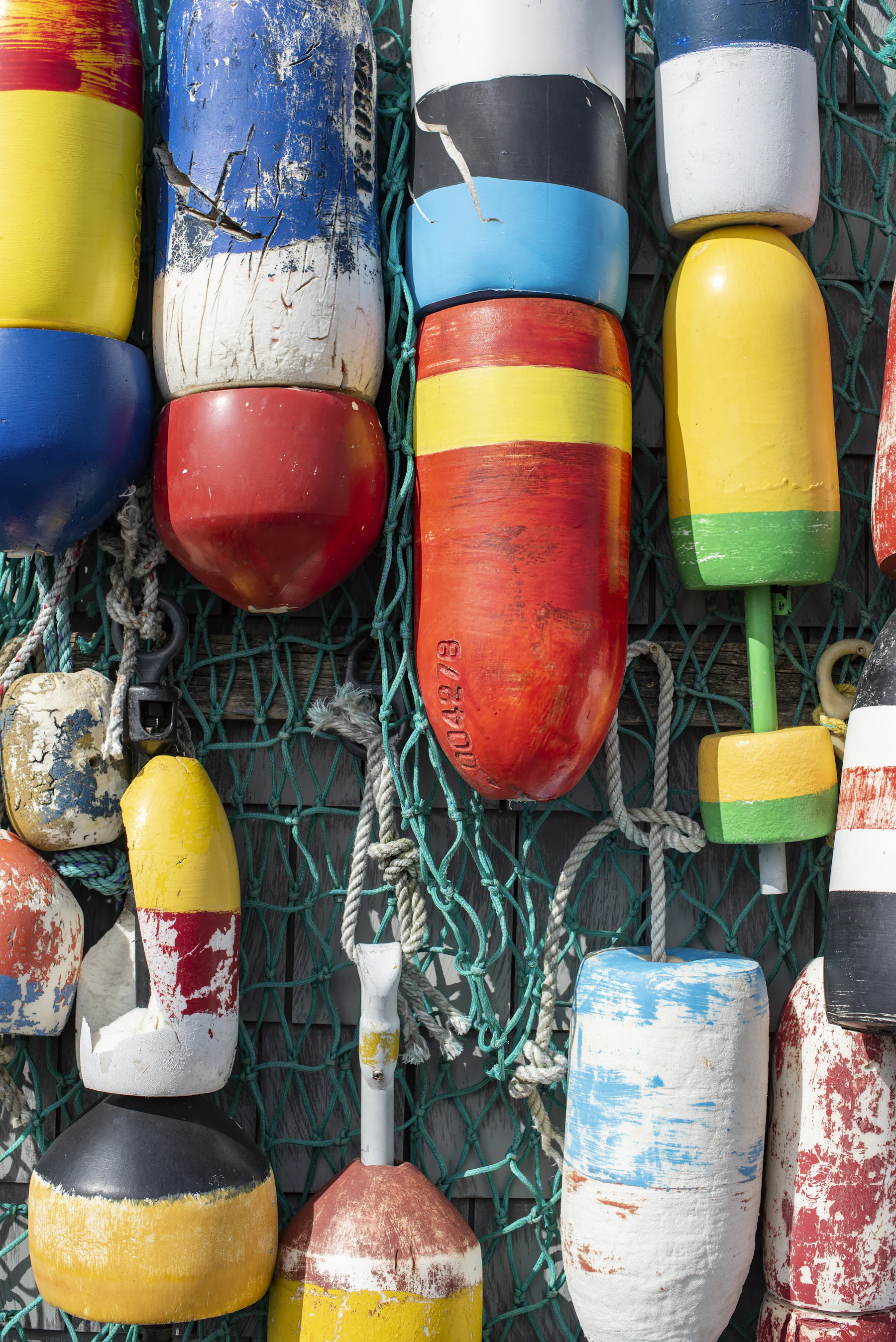A wall of colorful fishing buoys hung in rows