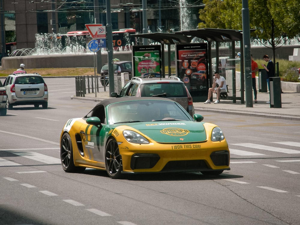 a yellow and green sports car driving down a street
