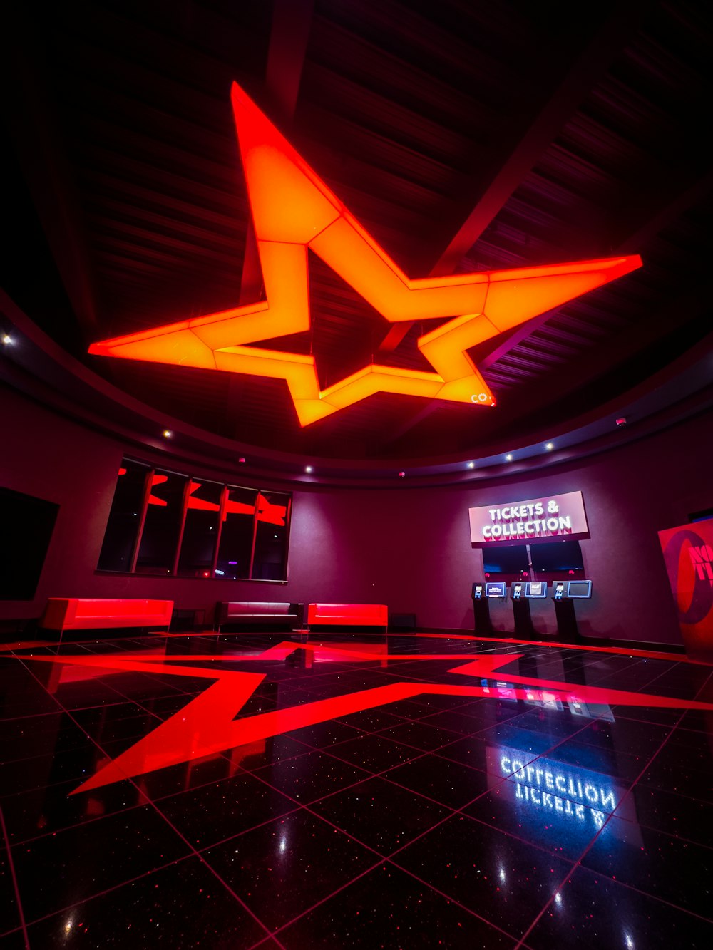 a large room with a black floor and red lighting
