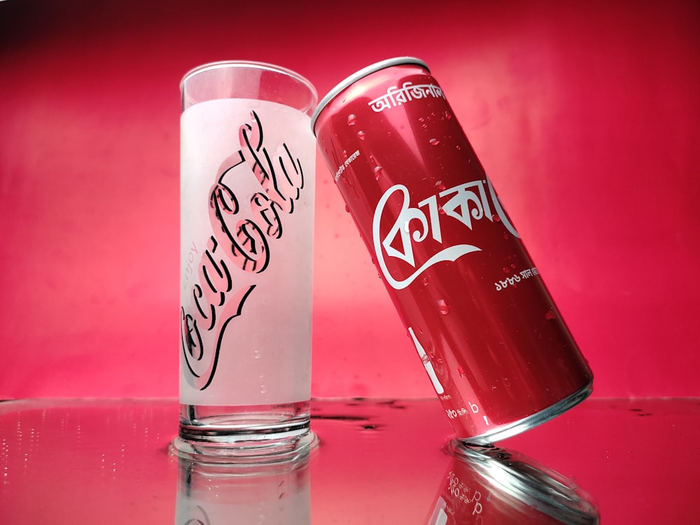 a red can and a white can sitting on a table