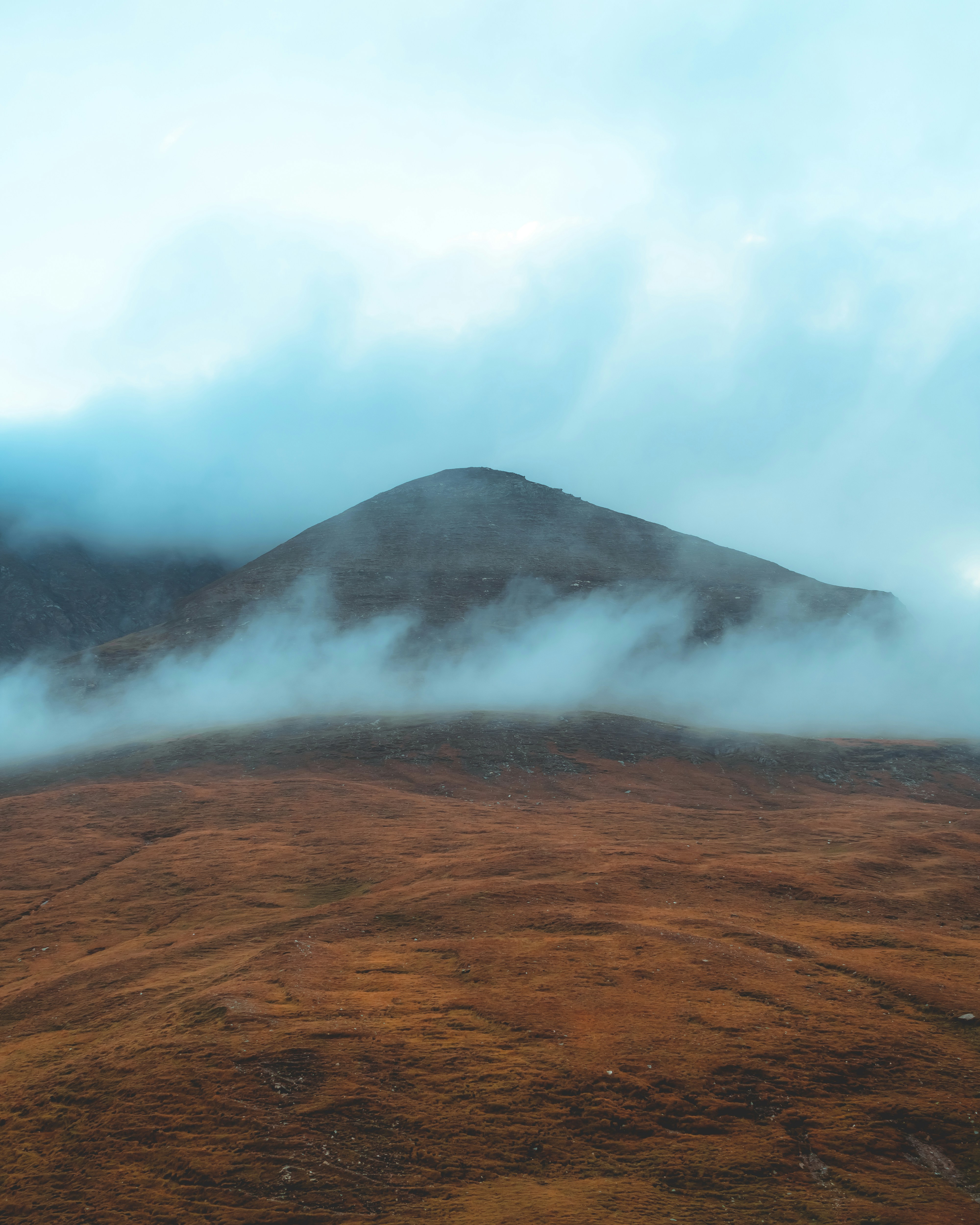 Ein Berg, der an einem bewölkten Tag mit Nebel und Wolken bedeckt ist