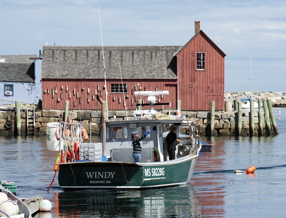 a boat in the water with a red building in the background
