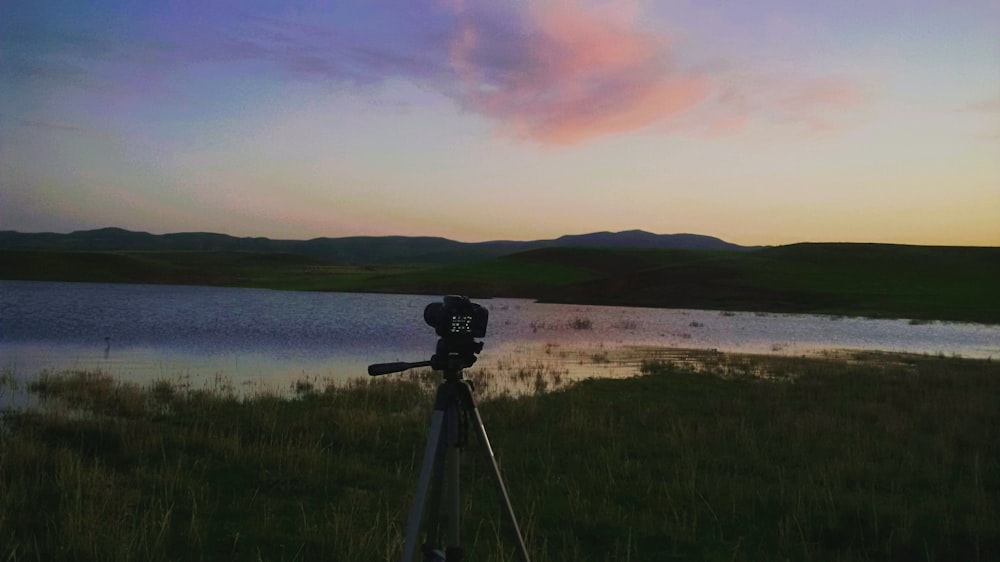 a camera on a tripod in front of a lake