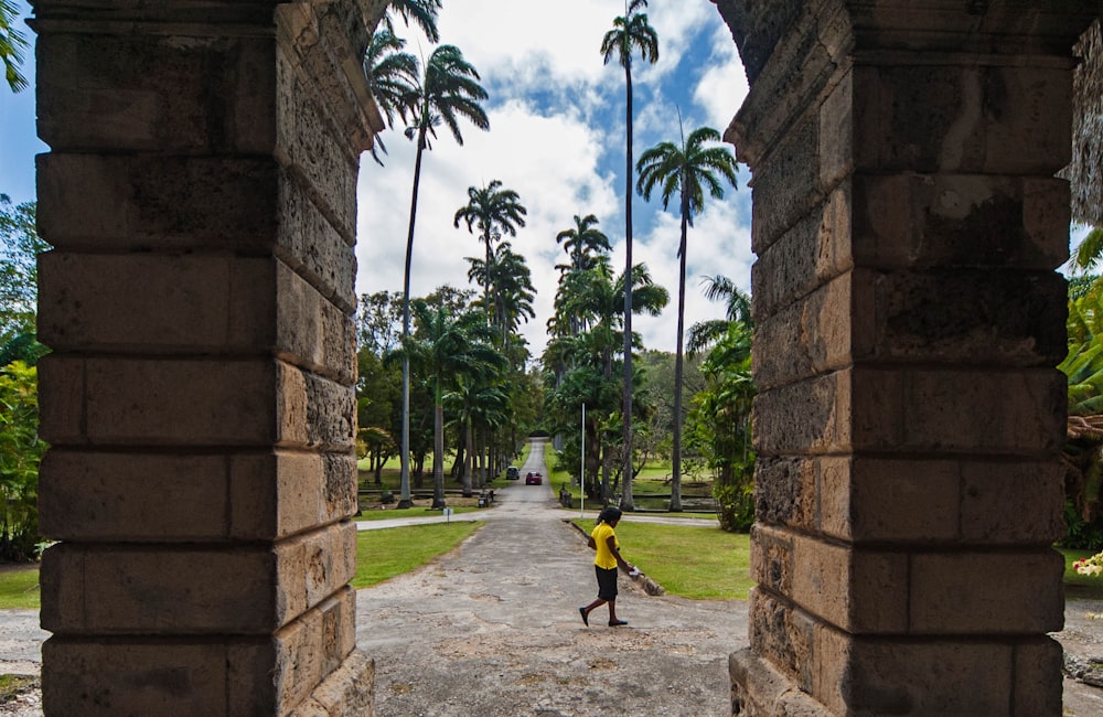 a person is walking through a stone archway