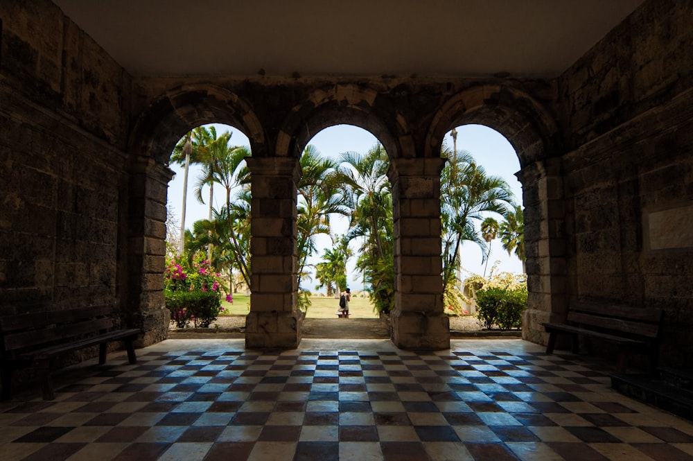 a room with a checkered floor and arches