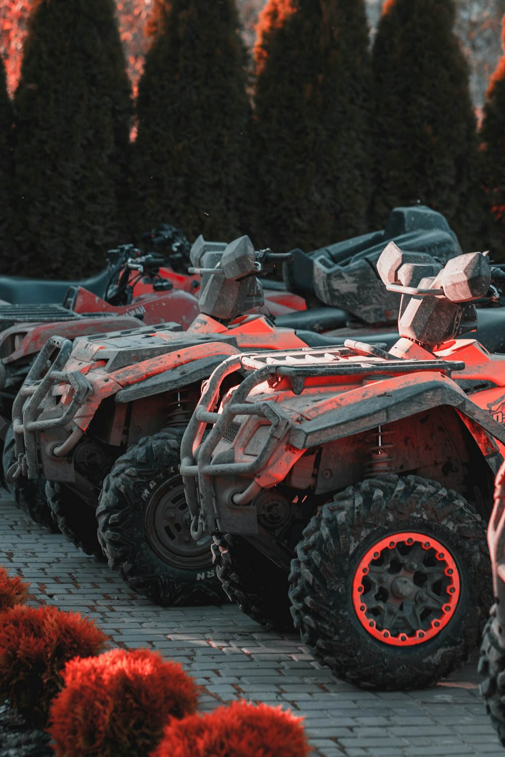 a row of four red four wheelers parked next to each other