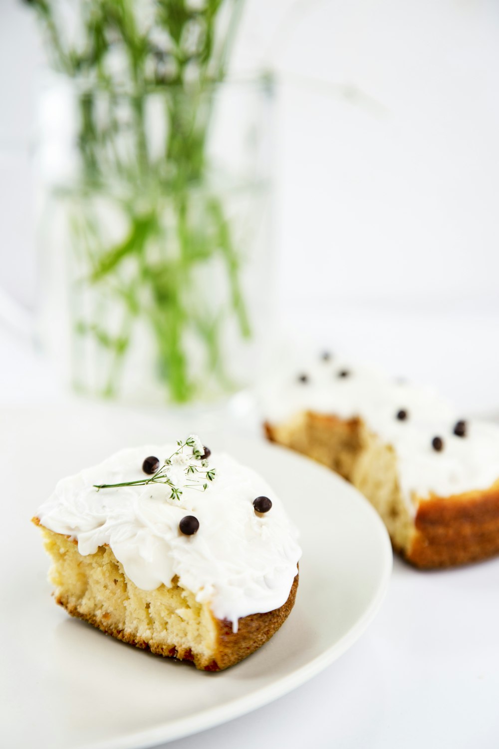 a white plate topped with a piece of cake covered in frosting