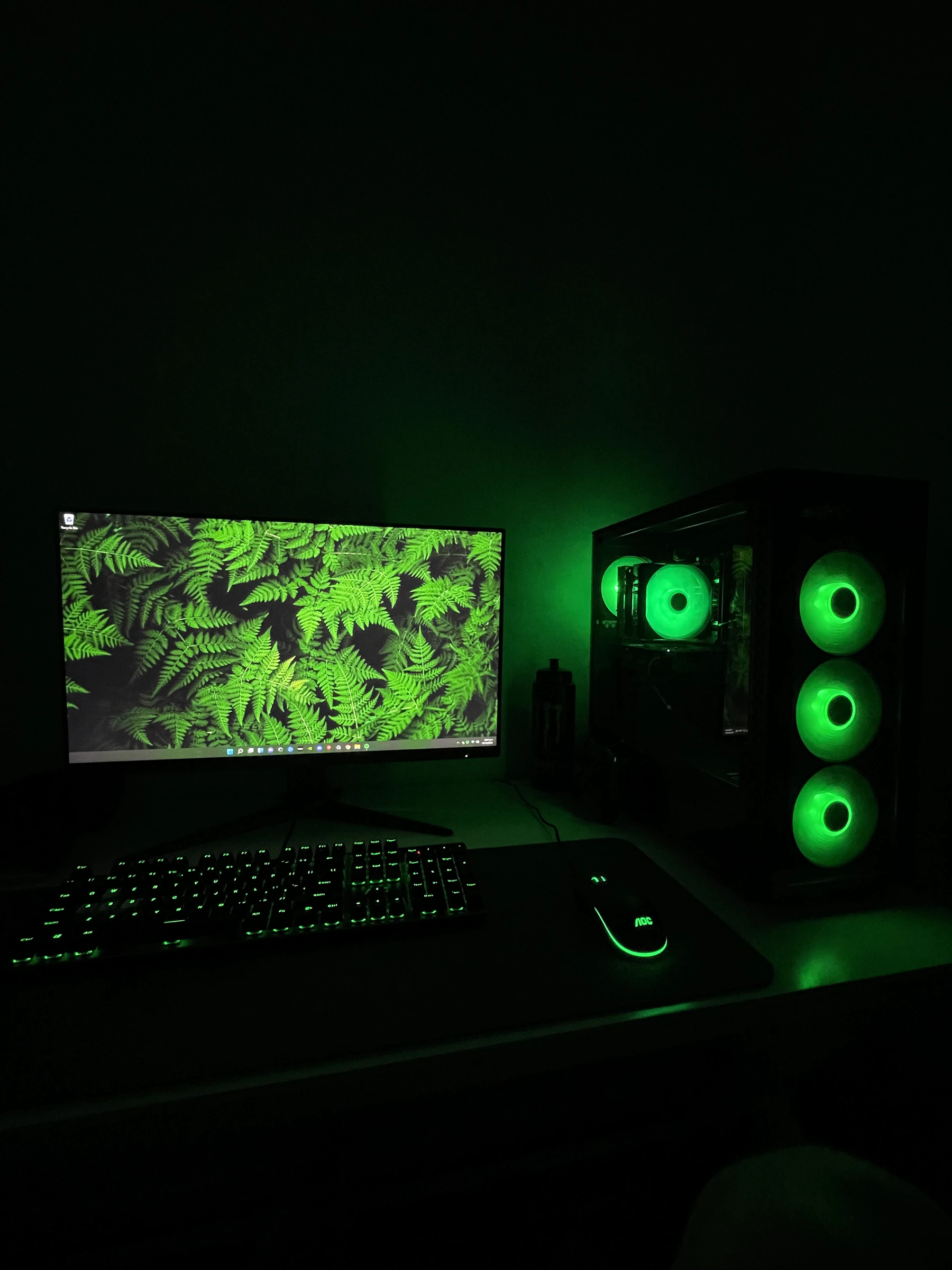 Dark PC gaming setup with a green-lit monitor