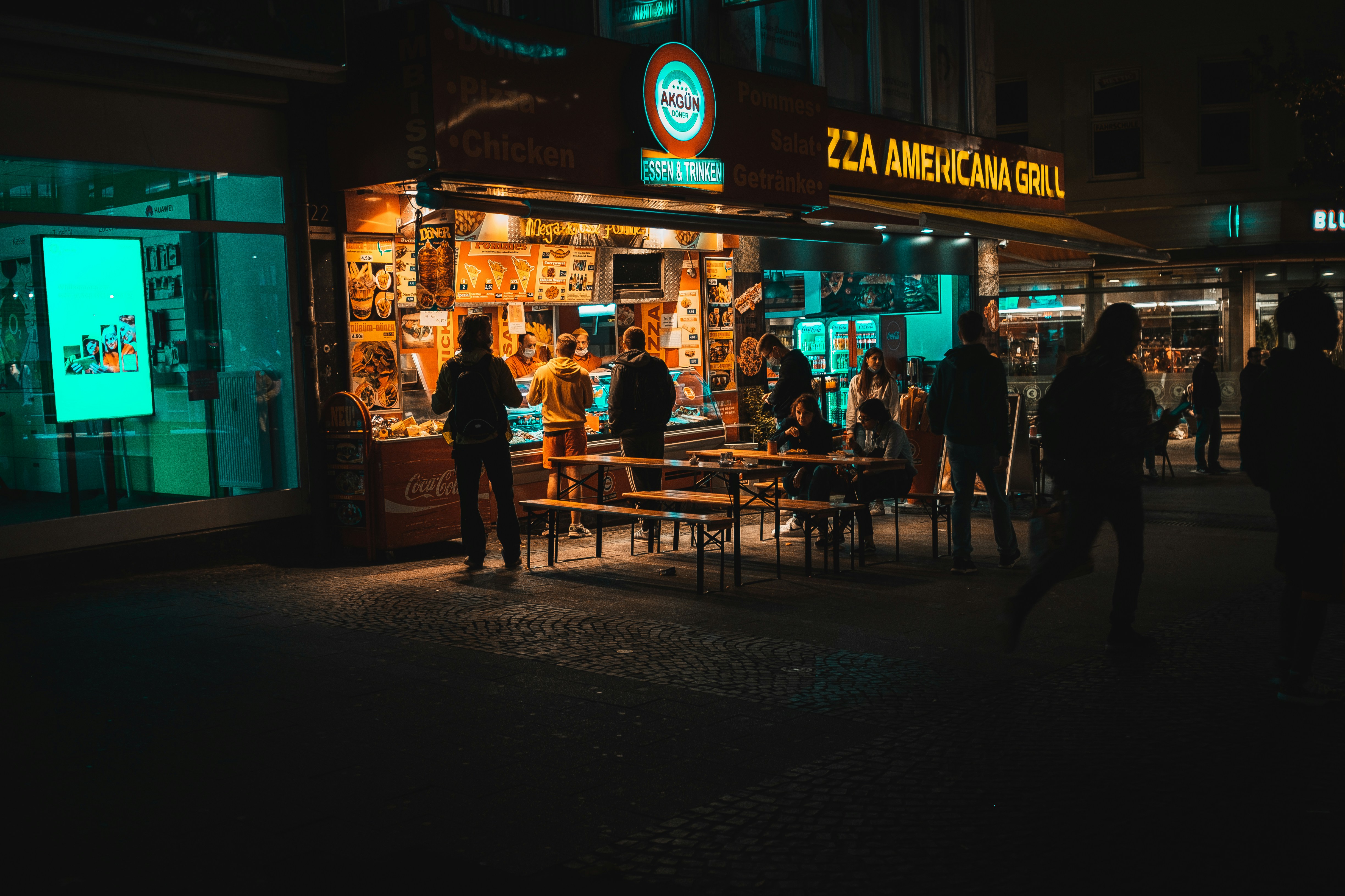 a group of people standing outside of a store at night