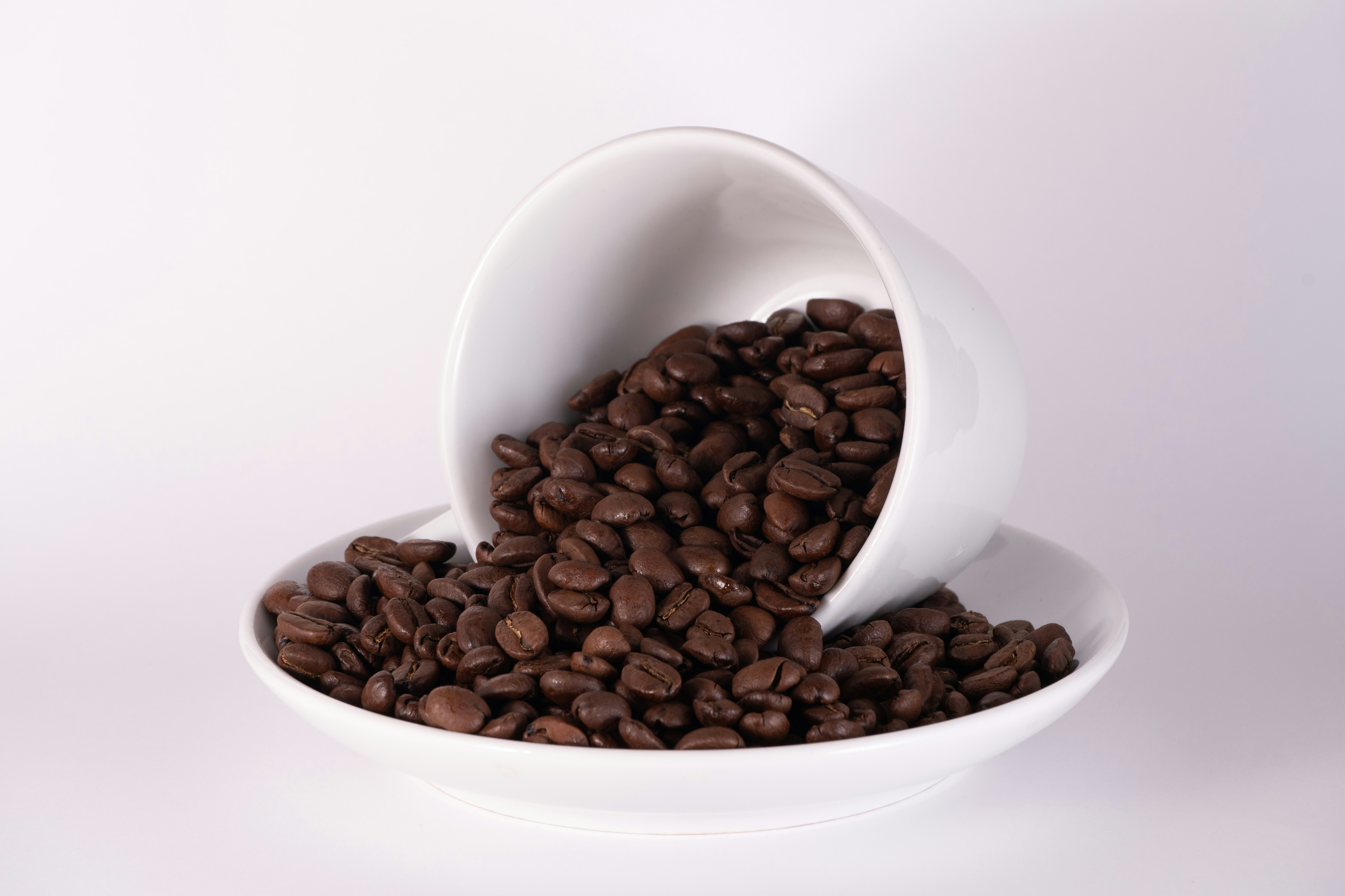 a white bowl filled with lots of coffee beans