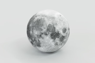 A realistic depiction of the moon appears to be isolated against a light gray background. The lunar surface shows clear details, including varying shades of gray, craters, and texture that emphasize its spherical form.