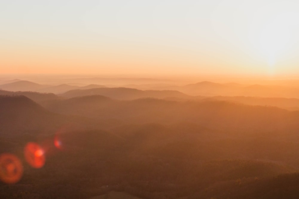 the sun is setting over a mountain range