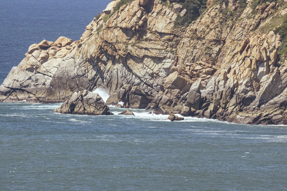 a large body of water next to a rocky cliff