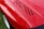 Close-up of a glossy red sports car hood reflecting sunlight after ceramic coating.