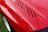 Close-up of a glossy red sports car hood reflecting sunlight after ceramic coating.