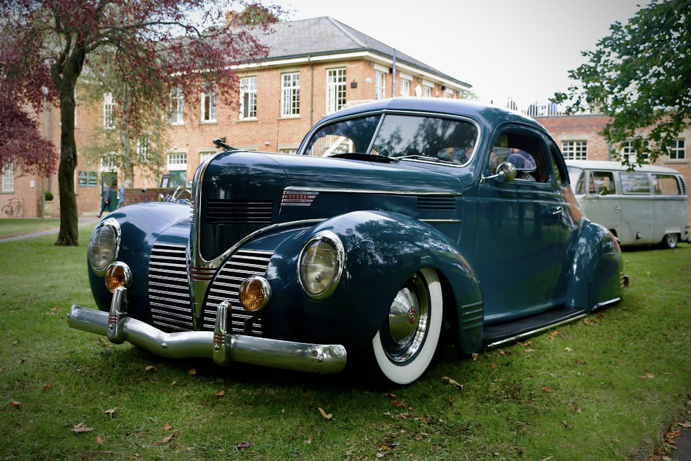 a classic car parked in front of a brick building