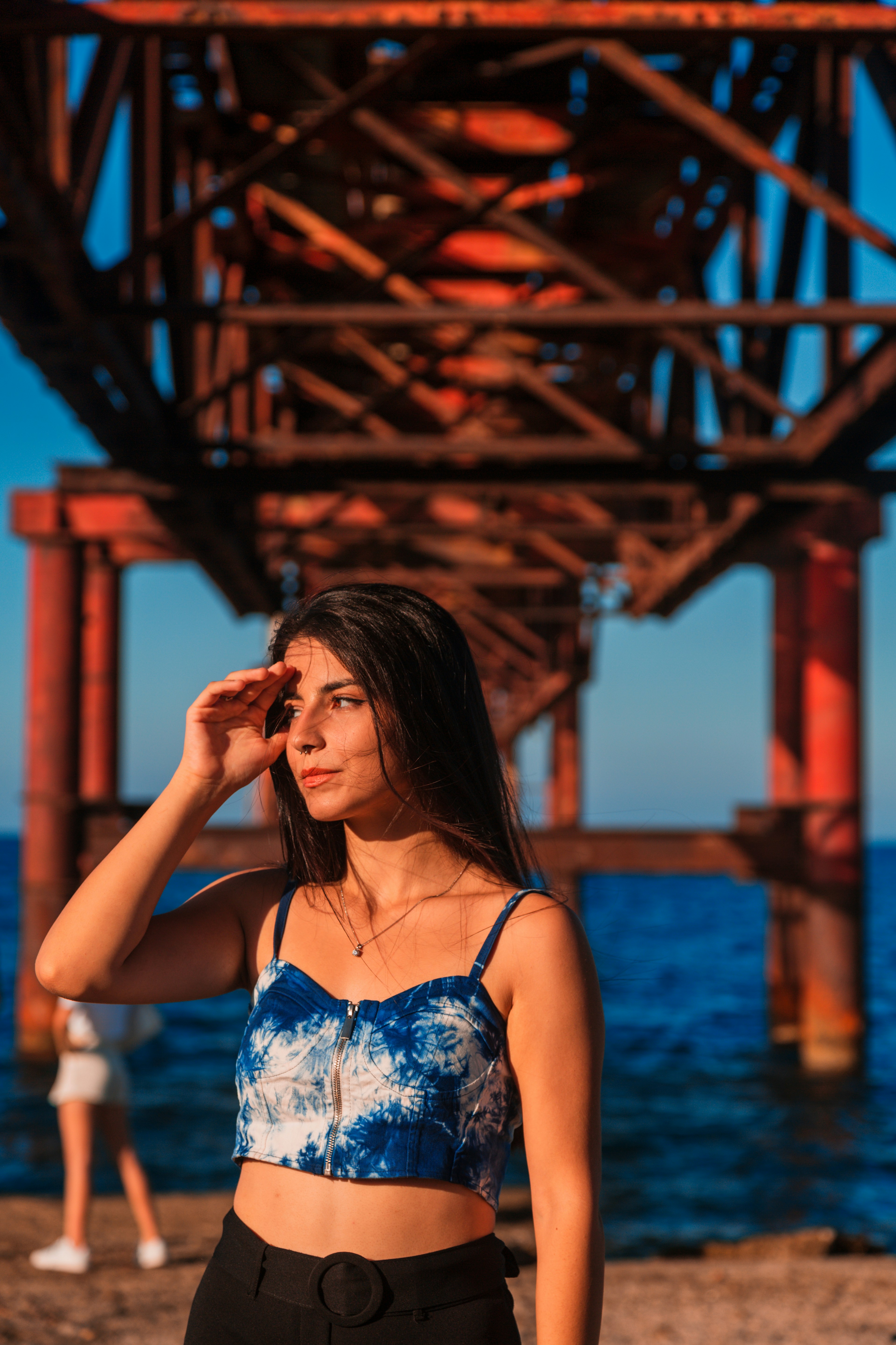 Une femme en crop top debout sous un pont