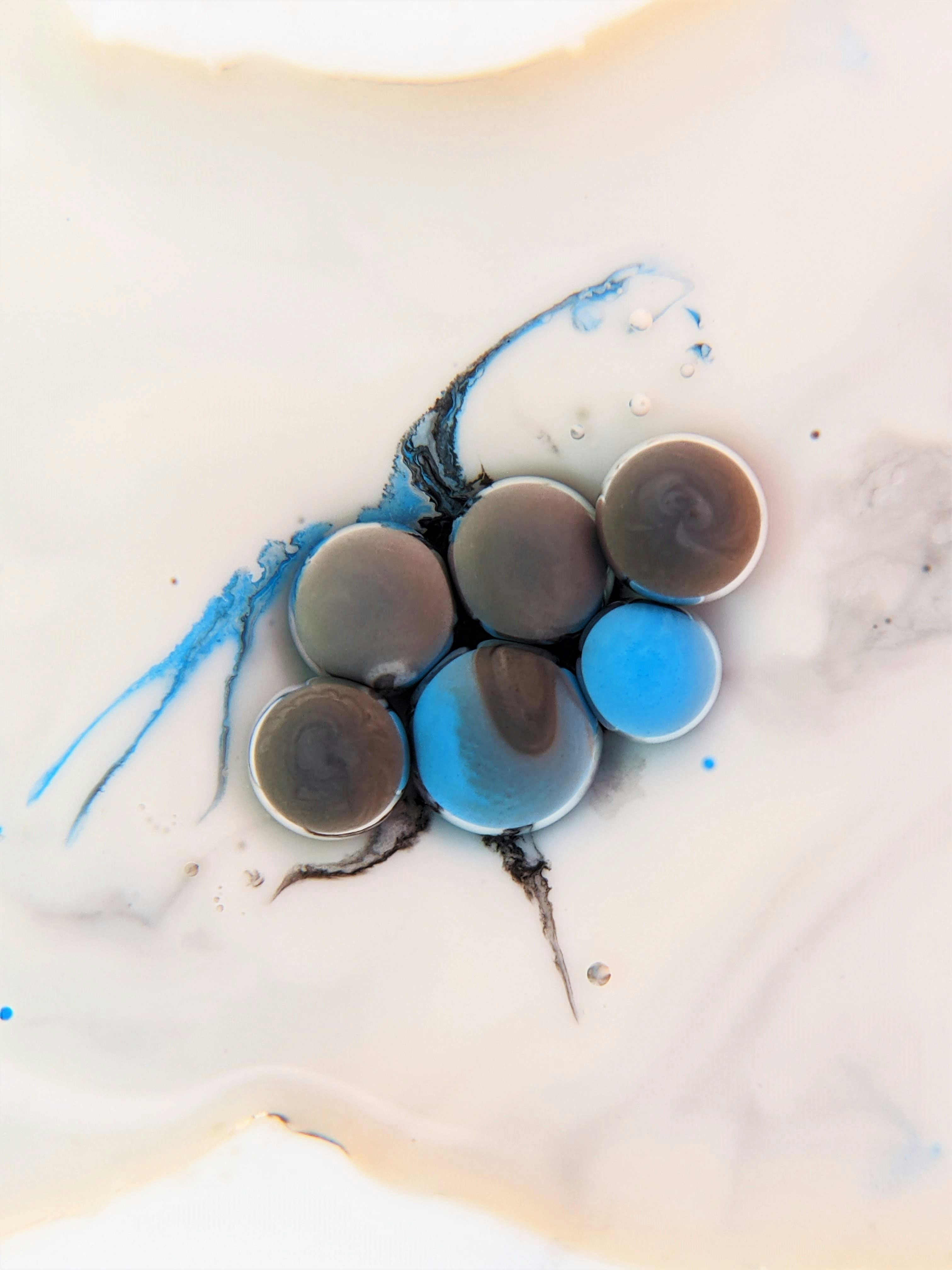 a group of blue and brown eggs sitting on top of a white surface