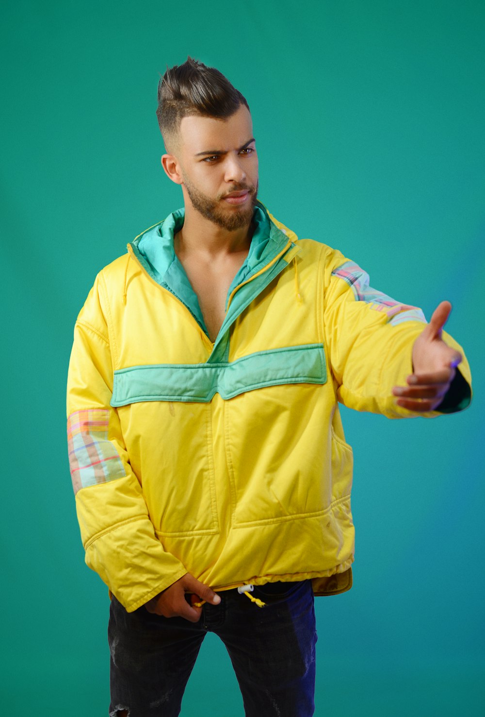 a man in a yellow jacket is giving a thumbs up