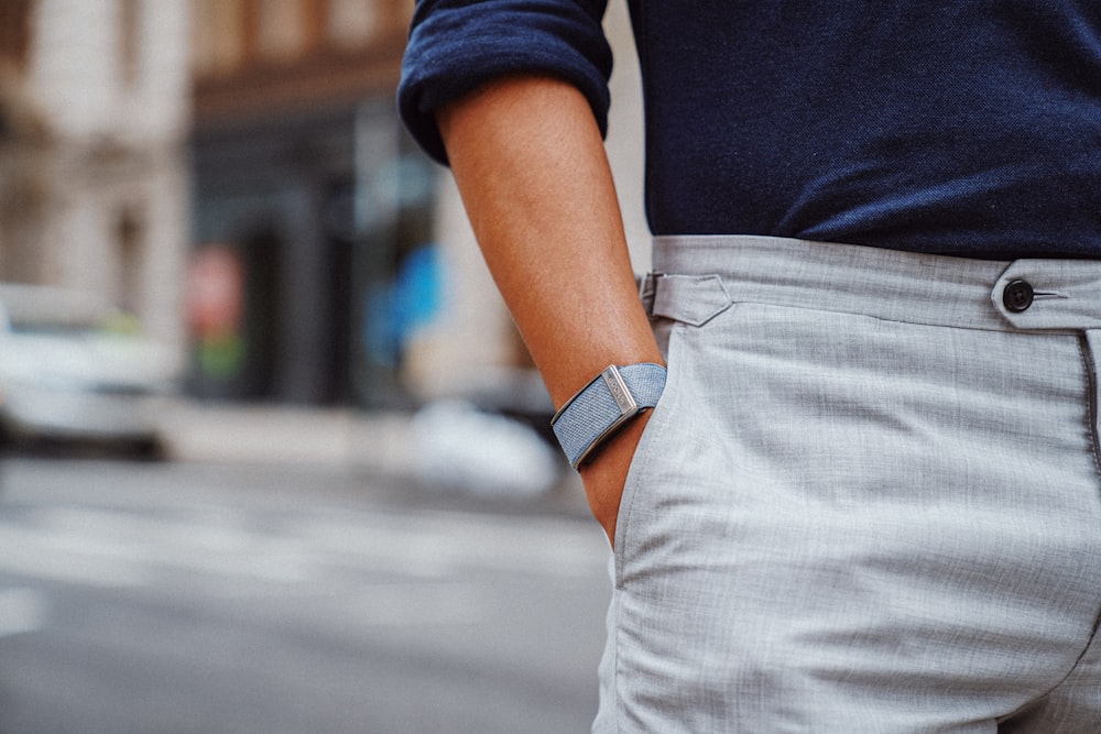 a close up of a person wearing a blue sweater and gray pants