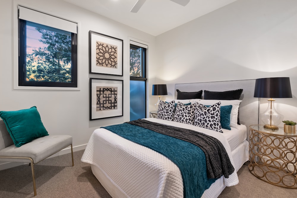 a bedroom with a bed, chair and pictures on the wall