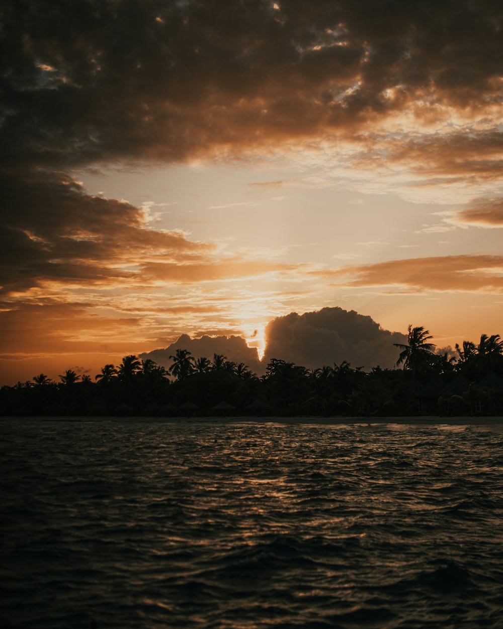 the sun is setting over a tropical island