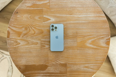 A close-up of a modern smartphone on a wooden table.