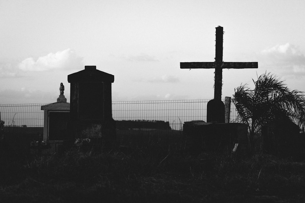 a black and white photo of a cemetery with a cross