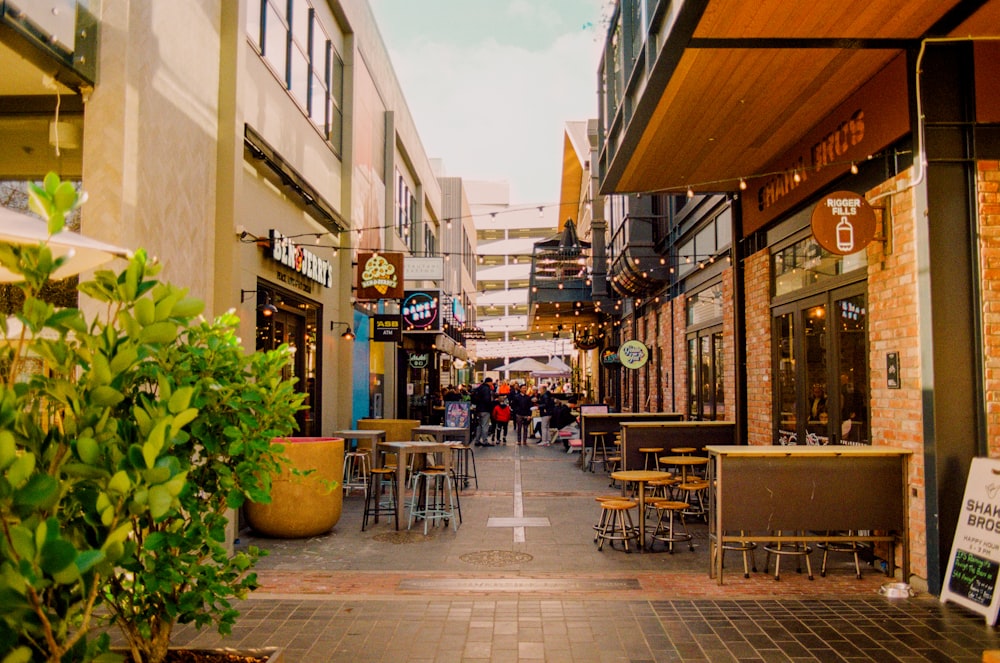 a city street with tables and chairs on the sidewalk