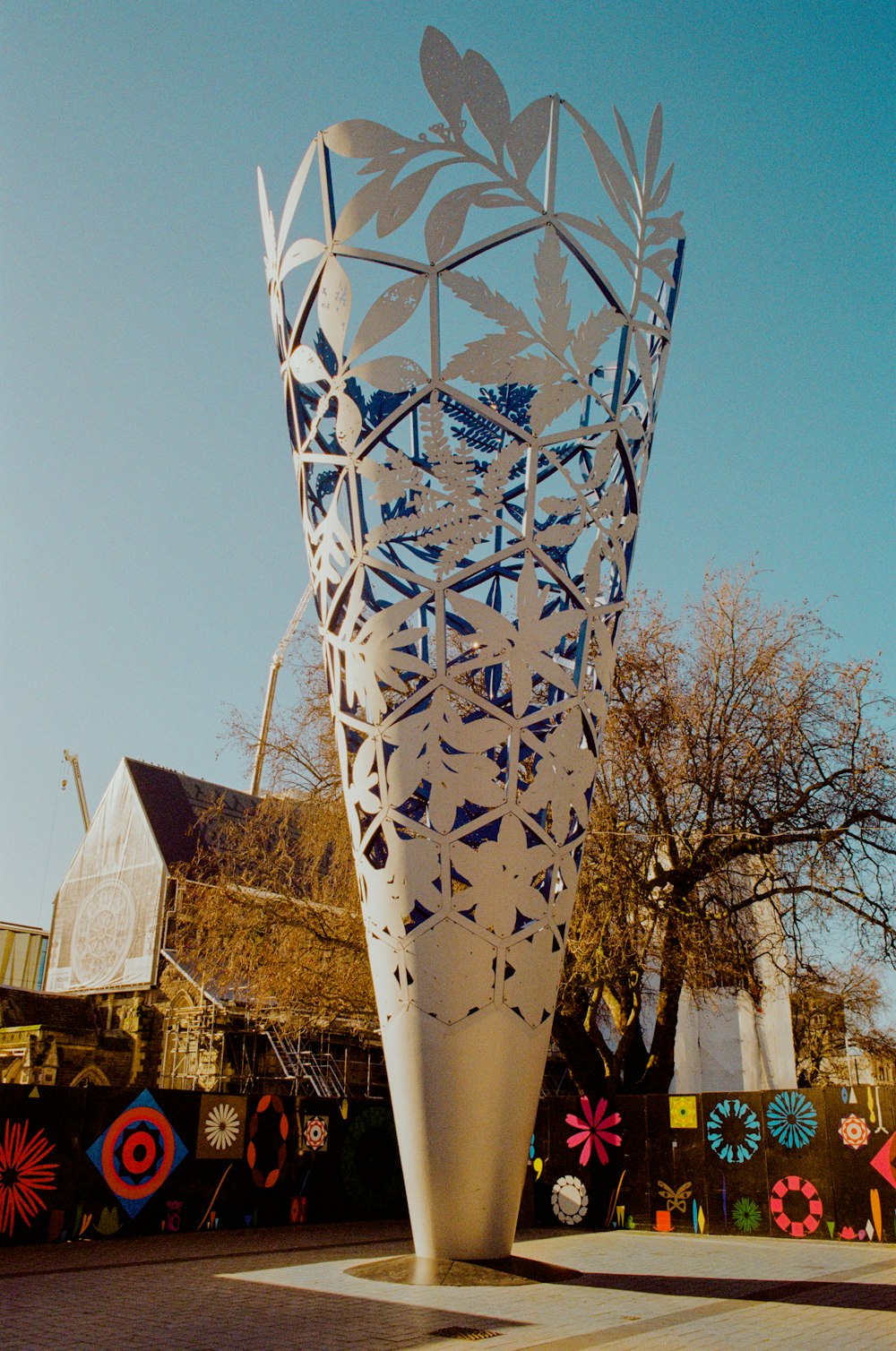 uma grande escultura de metal sentada no meio de um parque