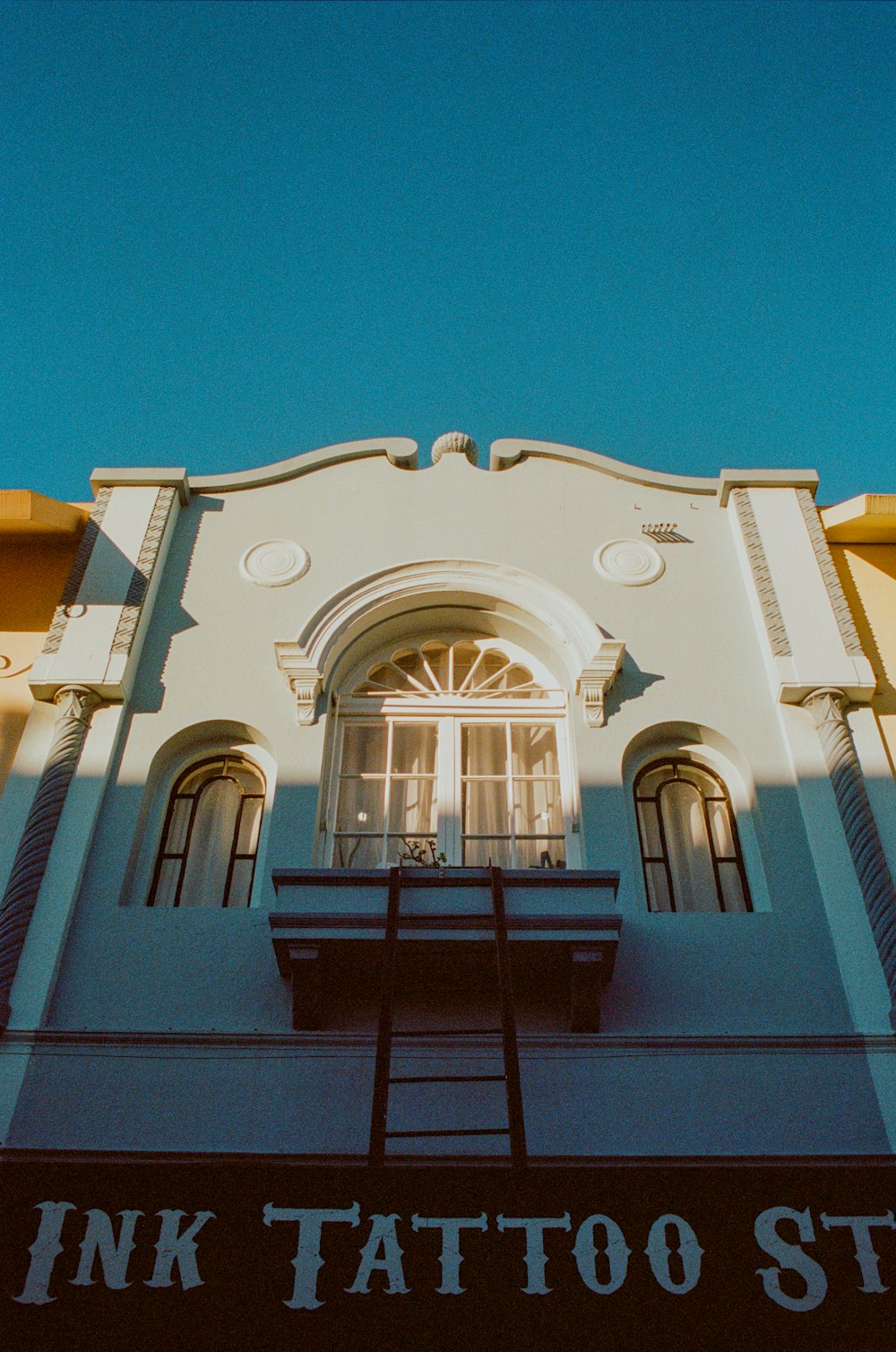 a building with a sign that says ink tattoo studio