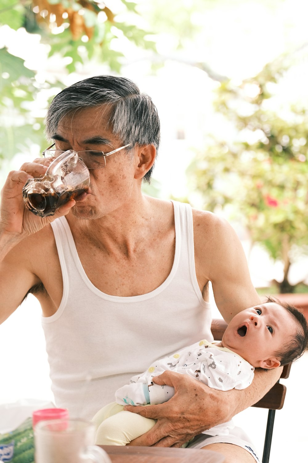 a man holding a baby drinking from a bottle
