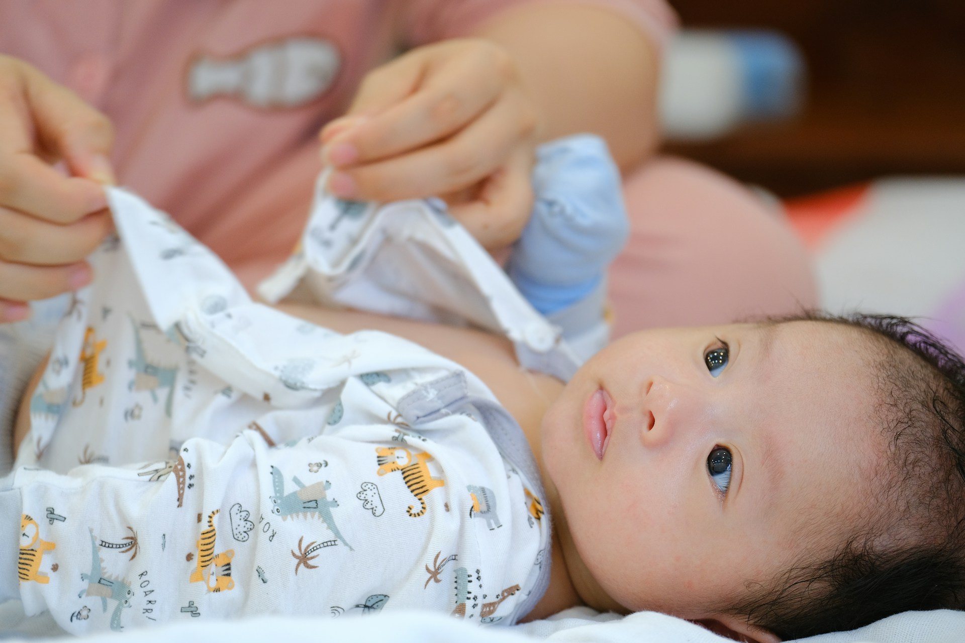 a baby laying on a bed holding a bottle