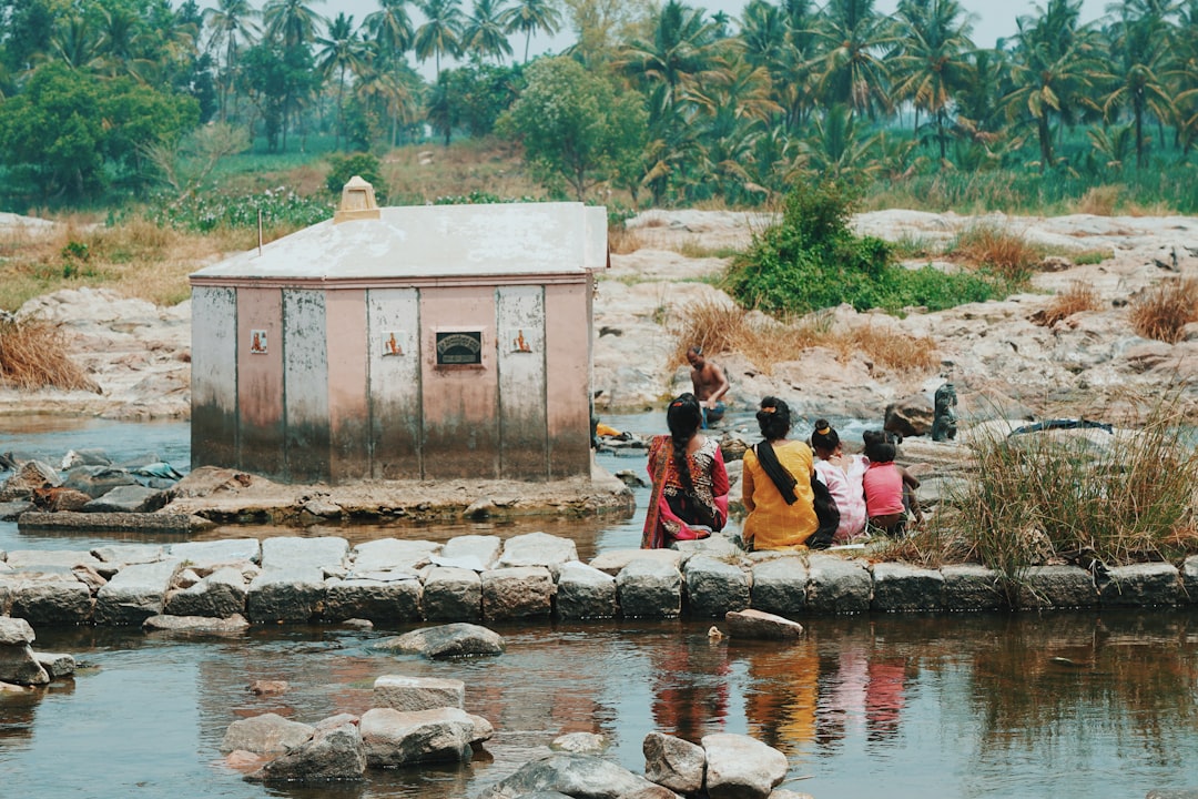 a group of people standing next to a body of water,