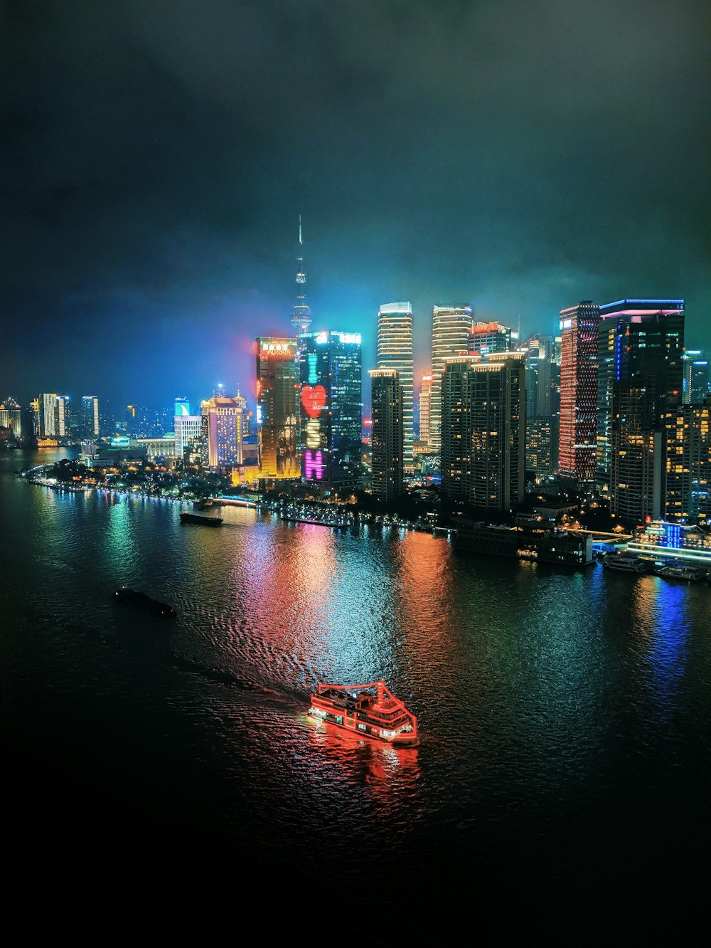 a boat floating on top of a body of water near a city