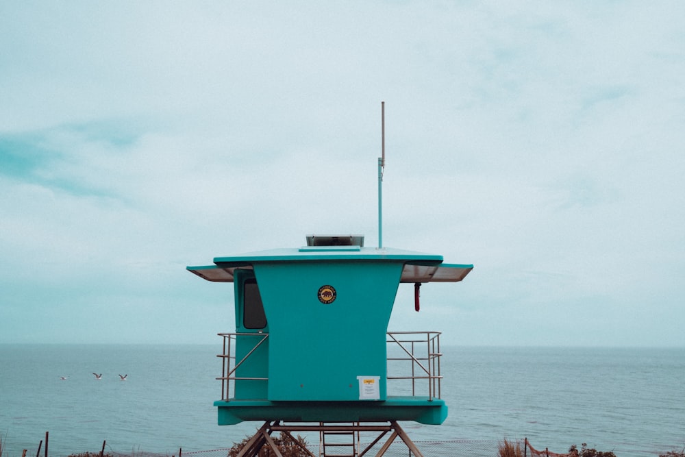 a blue lifeguard tower sitting on top of a beach