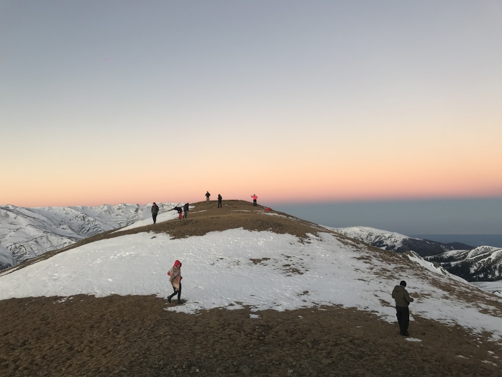 a group of people standing on top of a snow covered hill