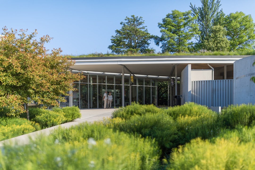 a building with a green roof surrounded by trees,
