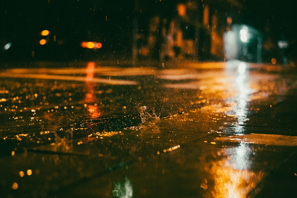 a wet sidewalk with a street light in the background