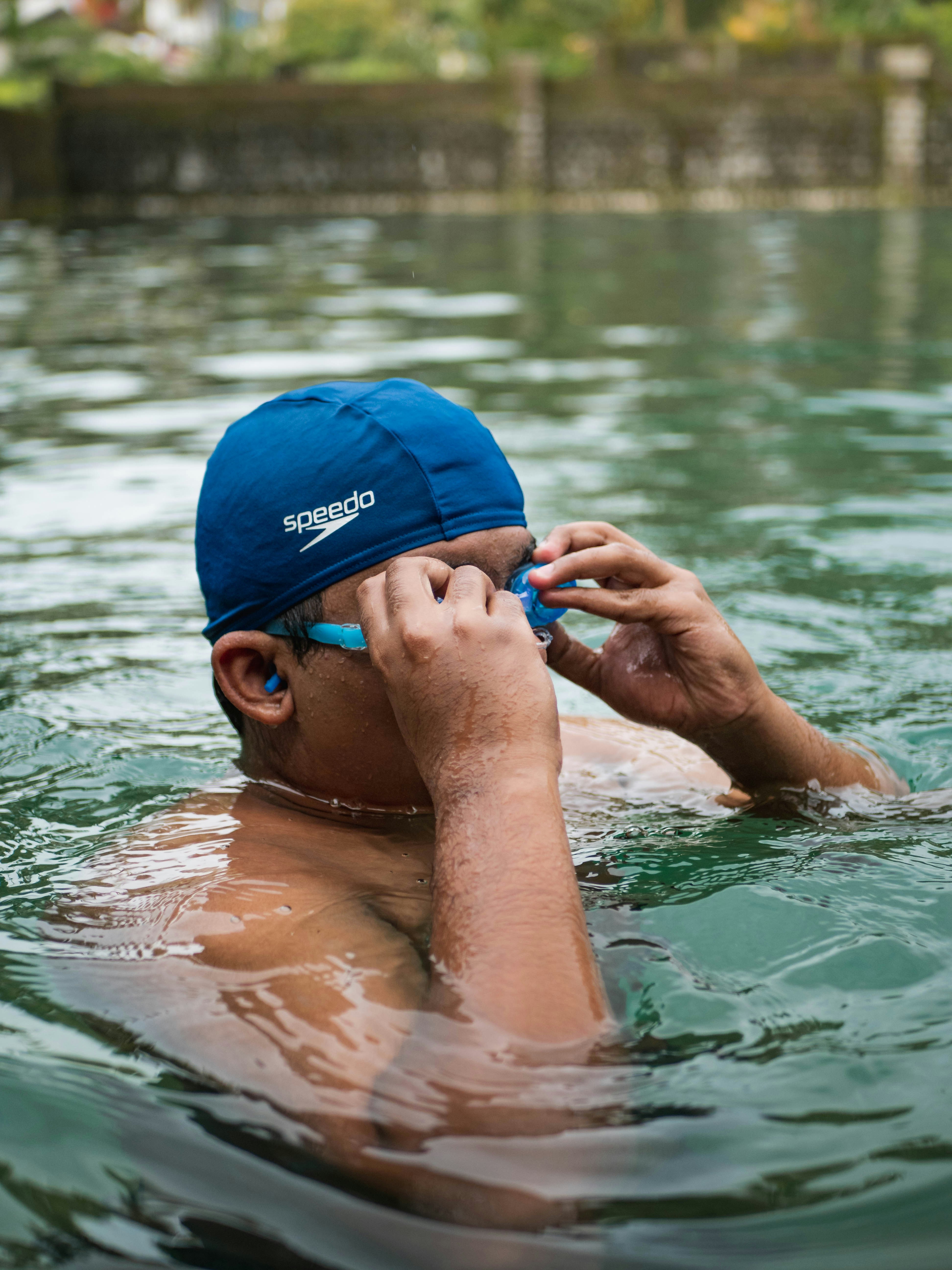 Un hombre con sombrero azul está en el agua