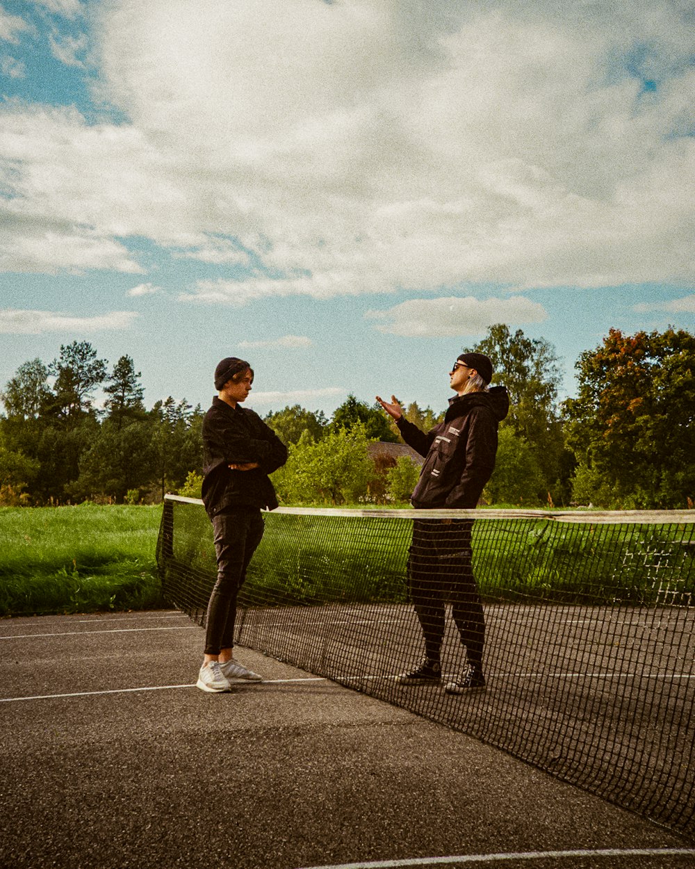 a couple of people standing on a tennis court