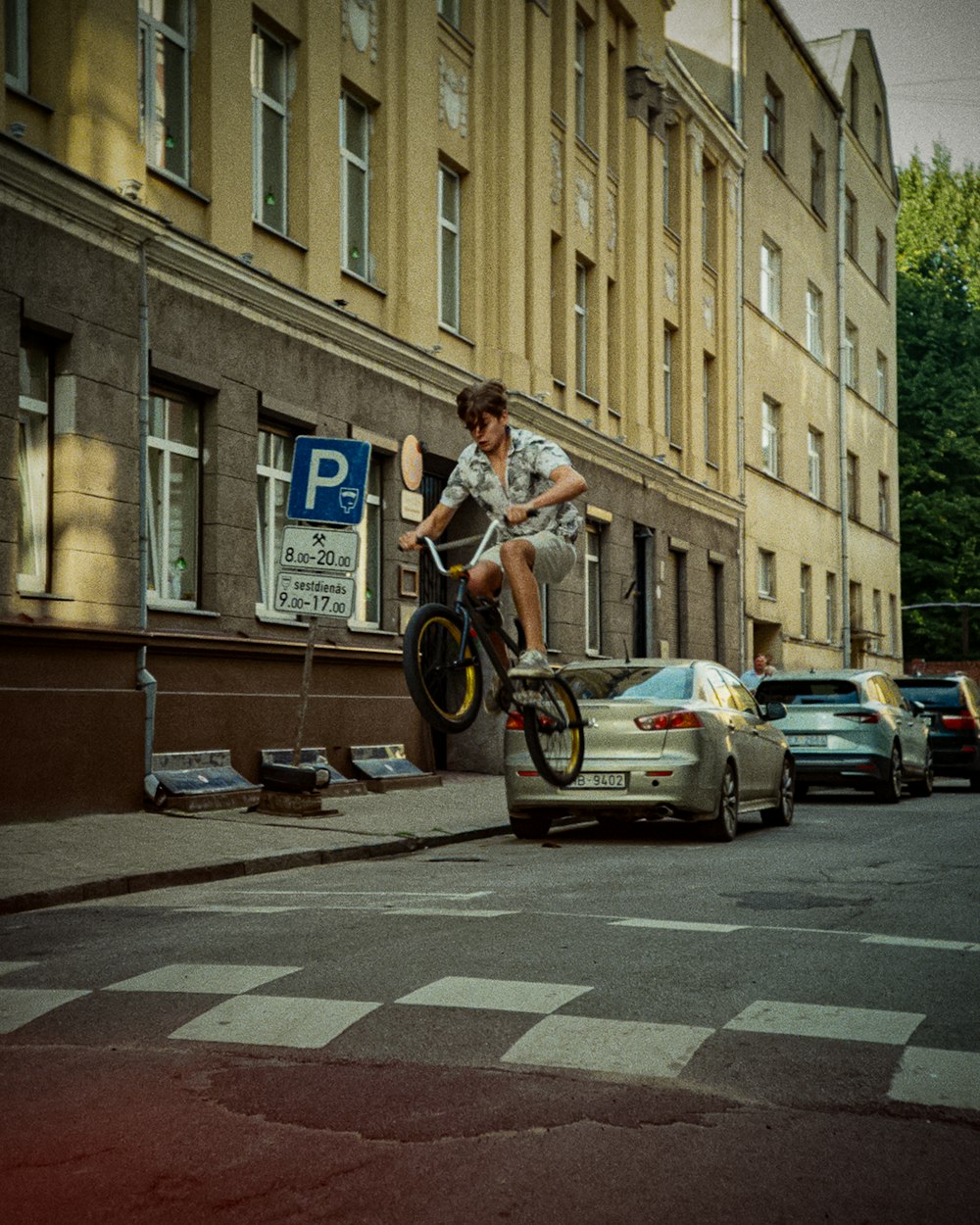 Un homme à vélo dans une rue à côté d’une voiture