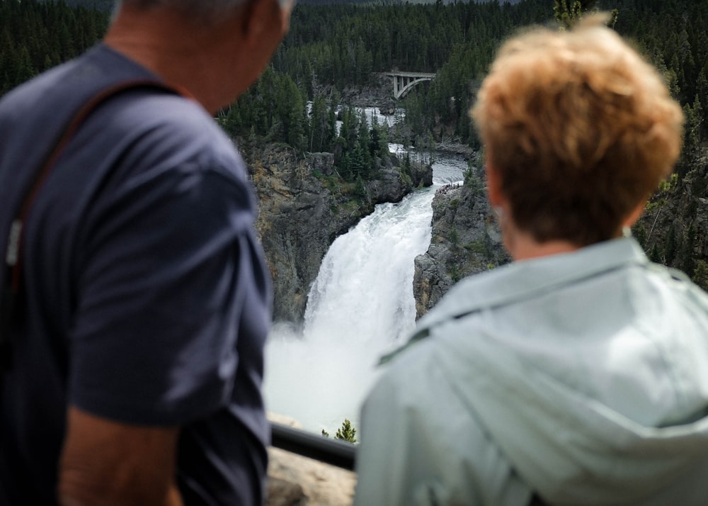 a man and a woman looking at a waterfall