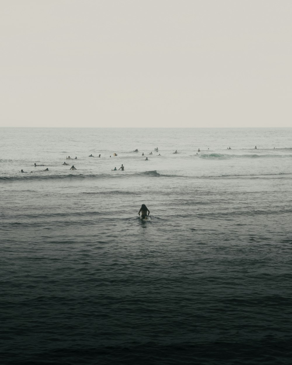 a group of people in the ocean with surfboards