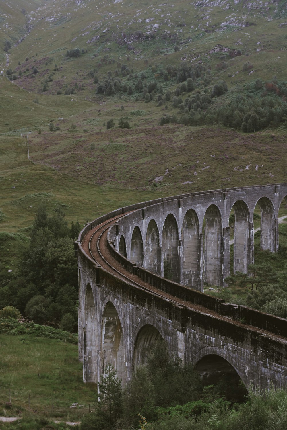 a train traveling over a bridge in the mountains