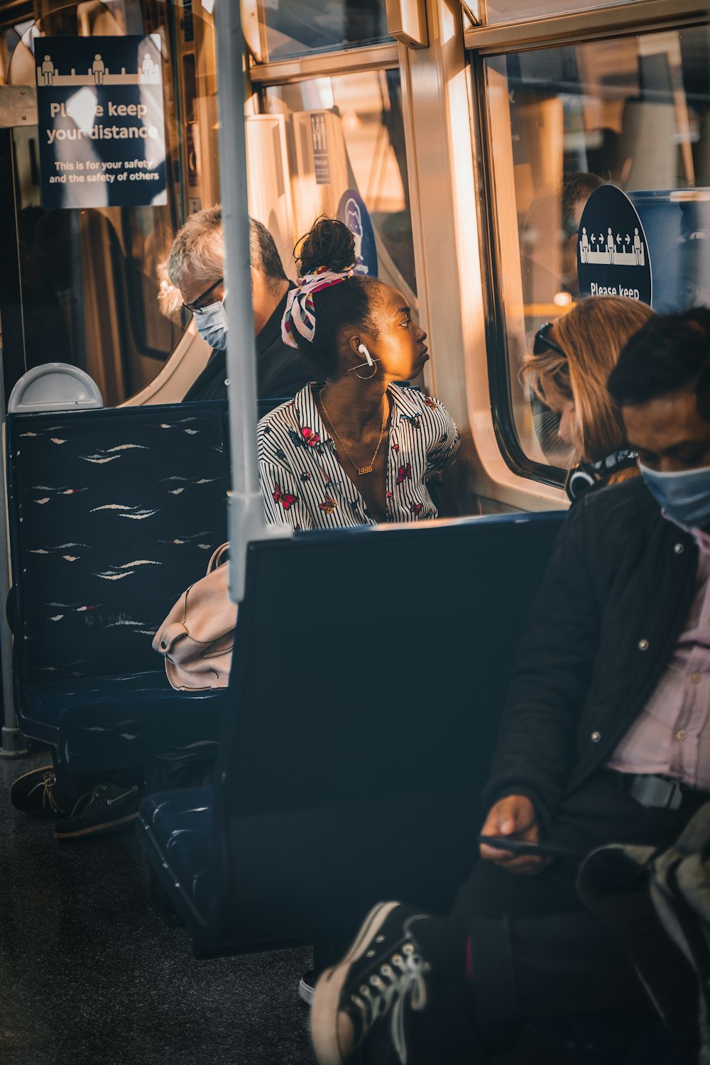 a group of people sitting on a bus looking at their laptops