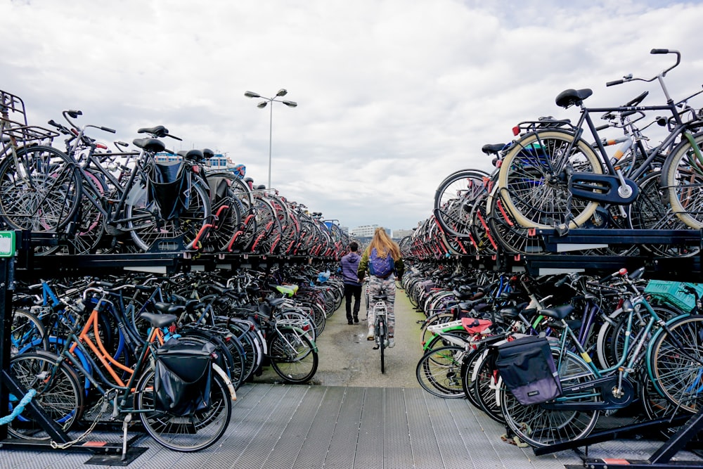 a person riding a bike through a large amount of bikes