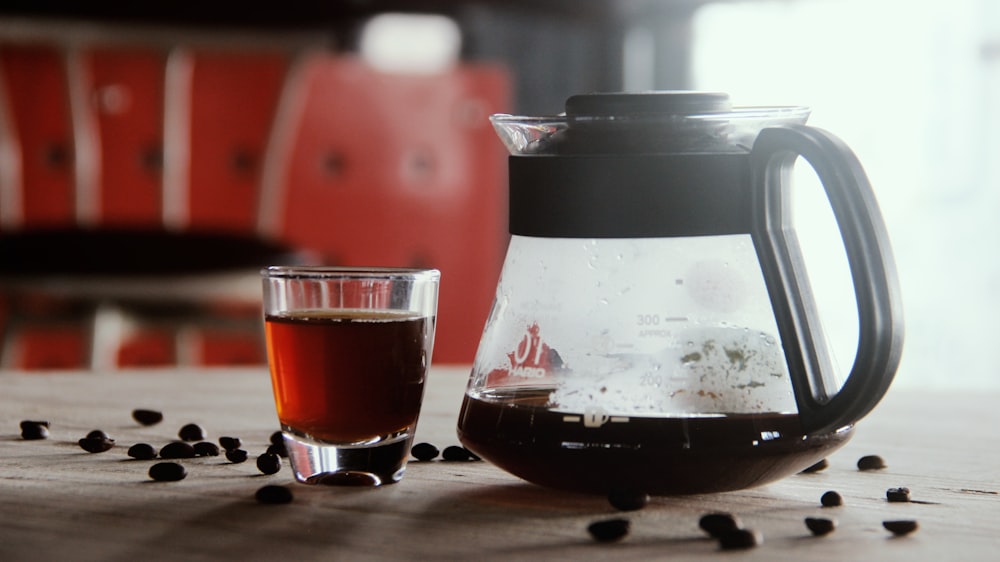 a pitcher of tea next to a glass of tea