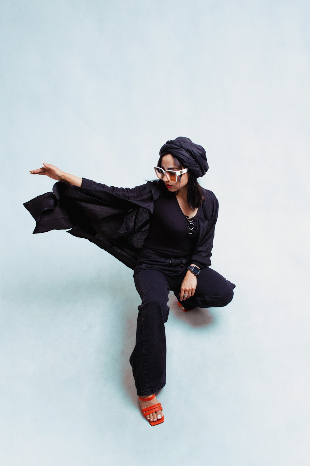 a woman sitting on the ground wearing a black outfit