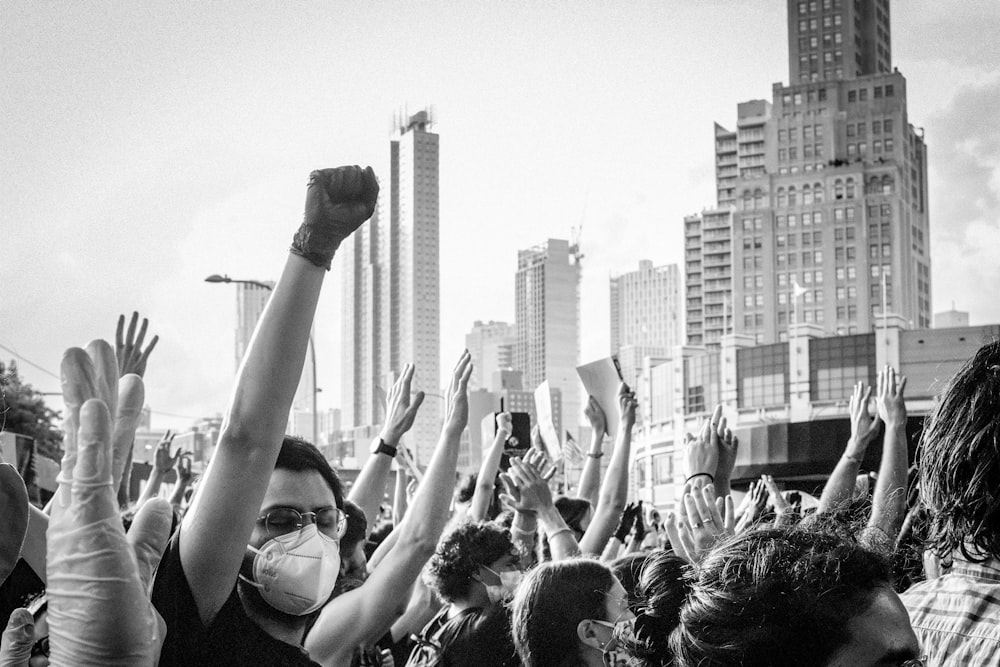 a crowd of people with their hands in the air